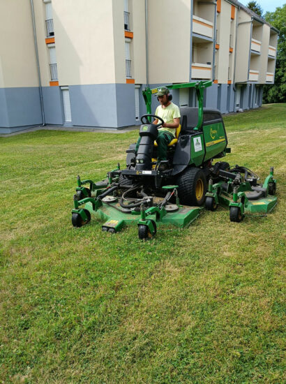 Jardinier paysagiste effectuant la tonte de pelouse